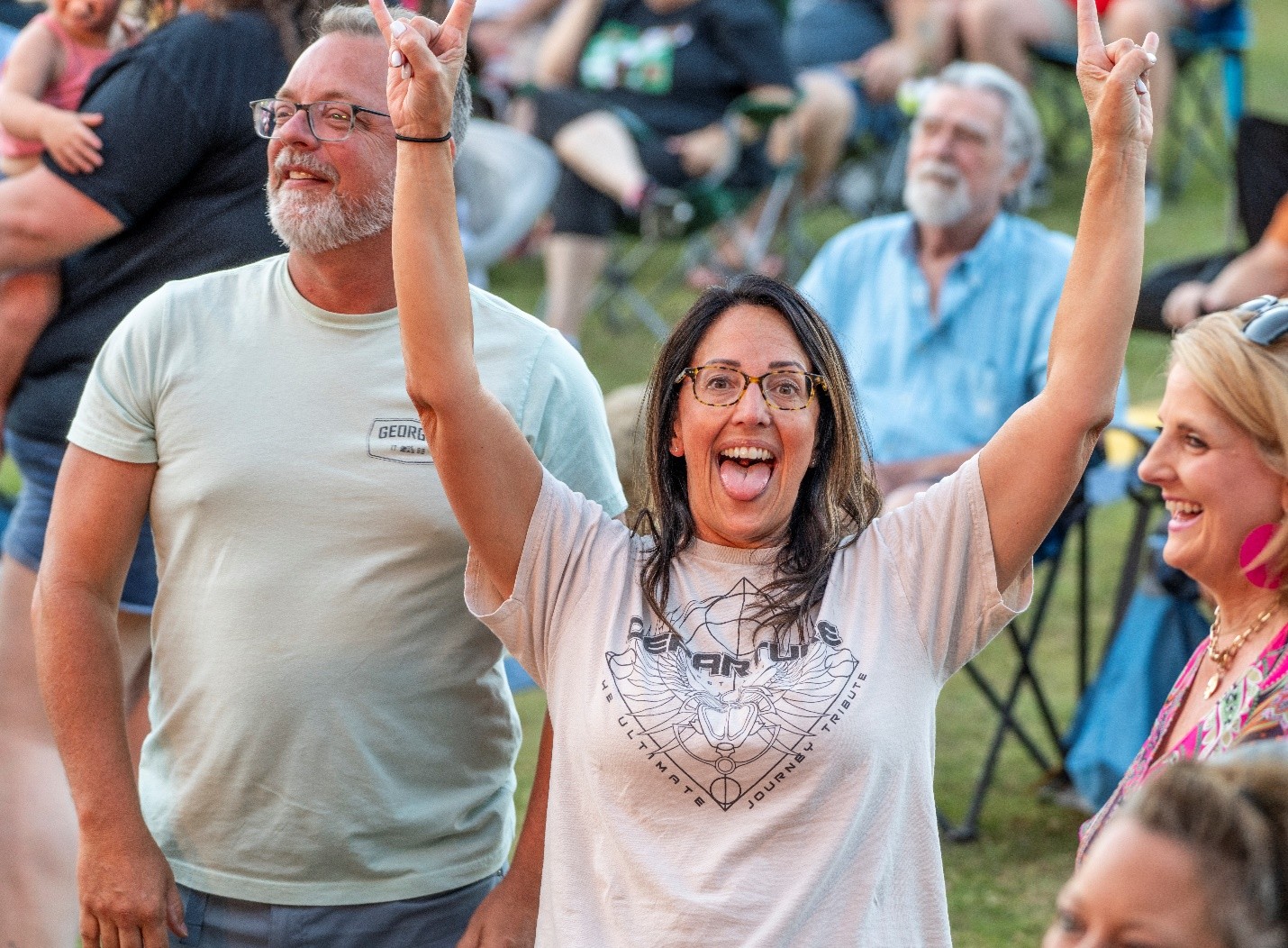 Women with tongue out and hands up in rock on gesture